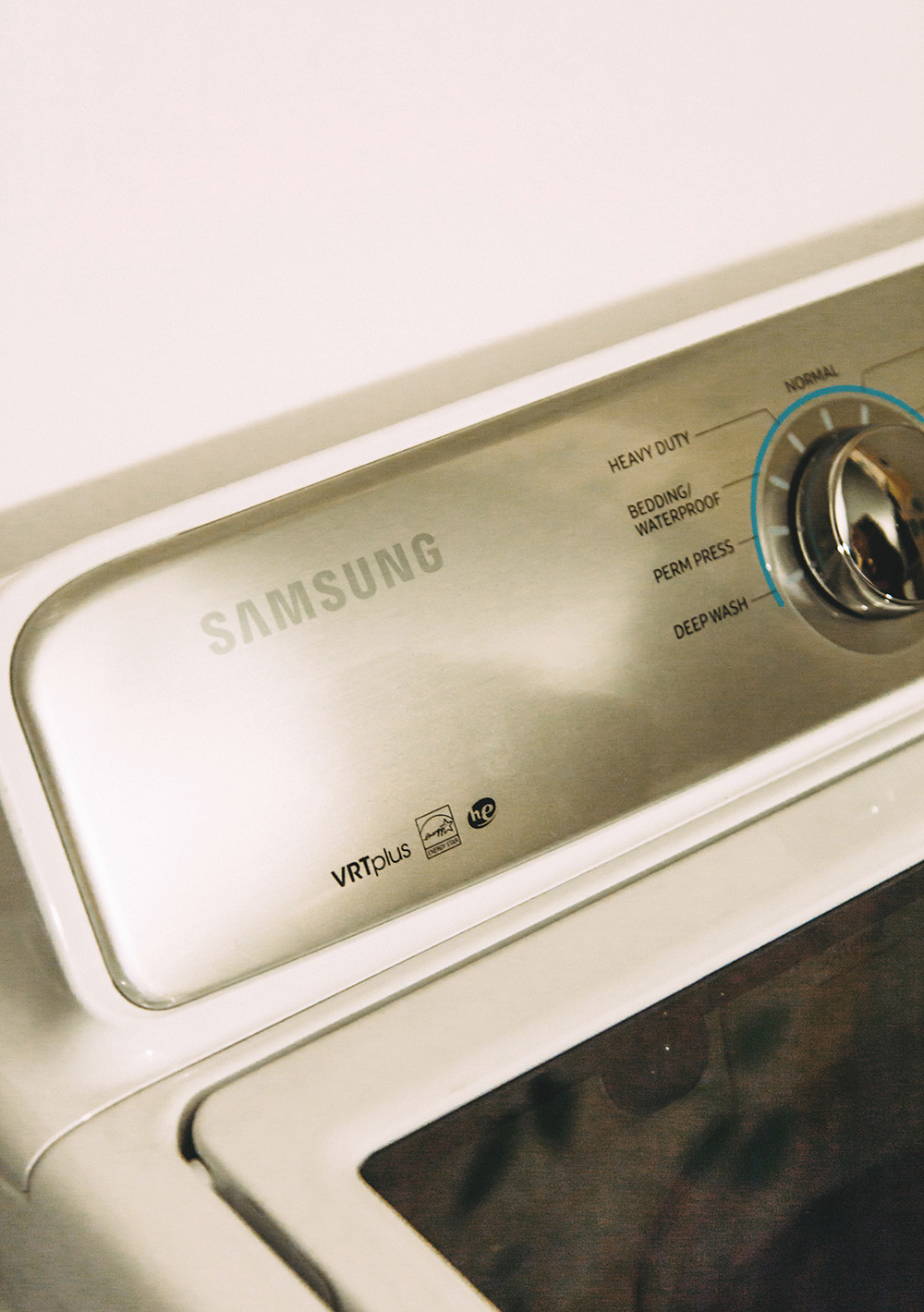 A white and silver Samsung top-load washing machine. A white and silver Samsung top-load washing machine.