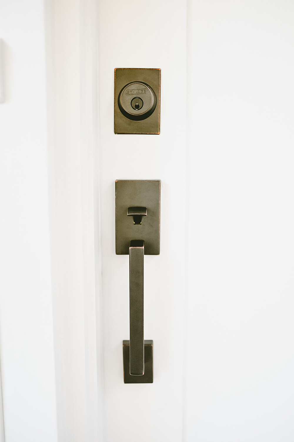A Schlage door handle on a white door.