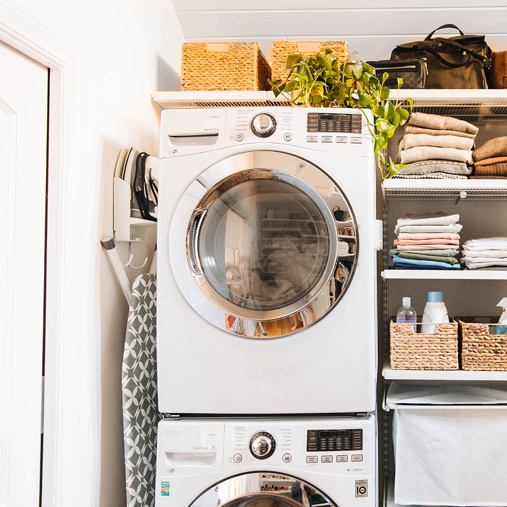 A small laundry room with a pair of white stacked appliances.