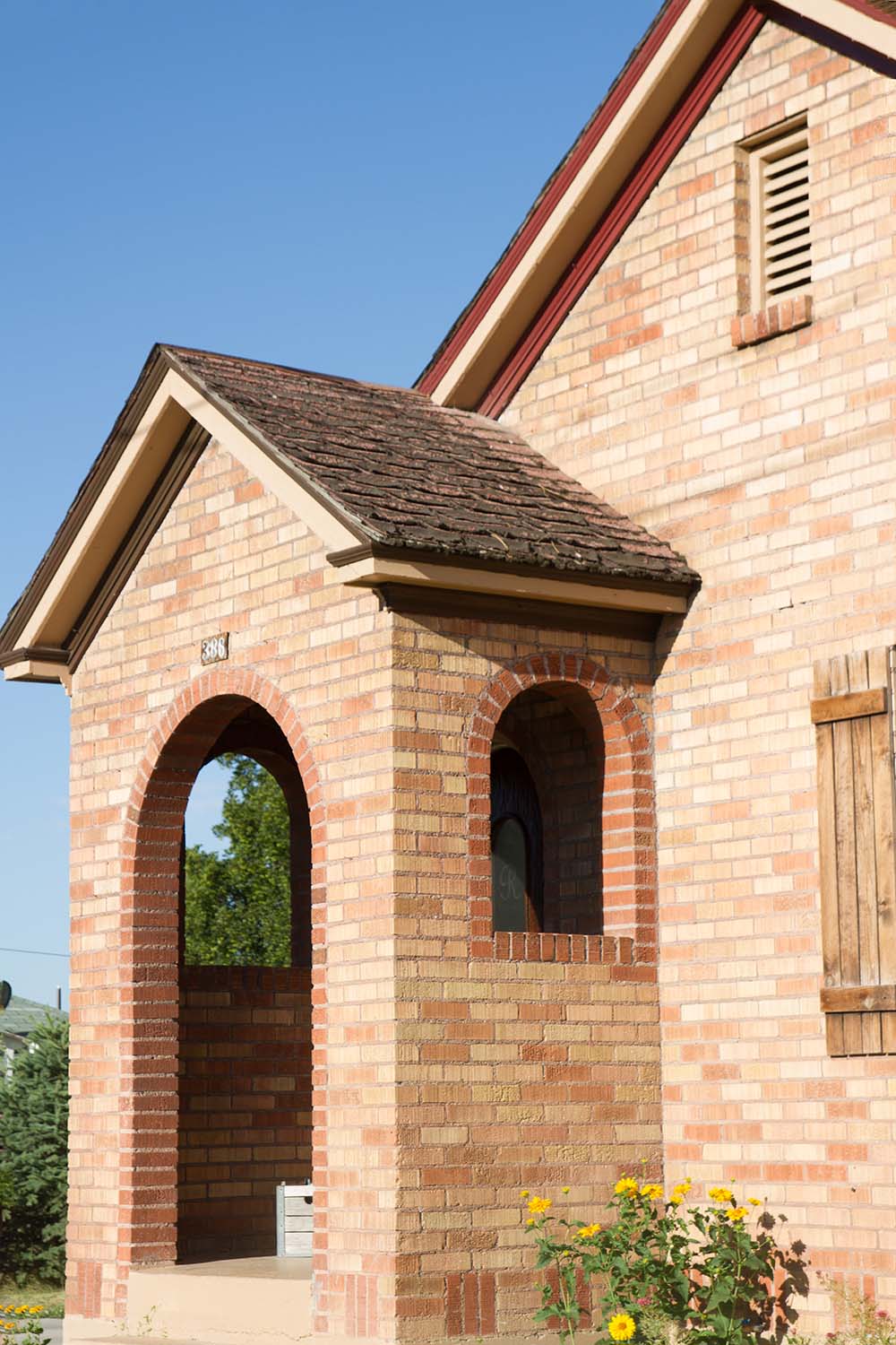 The front of a brick home with an arched entryway.