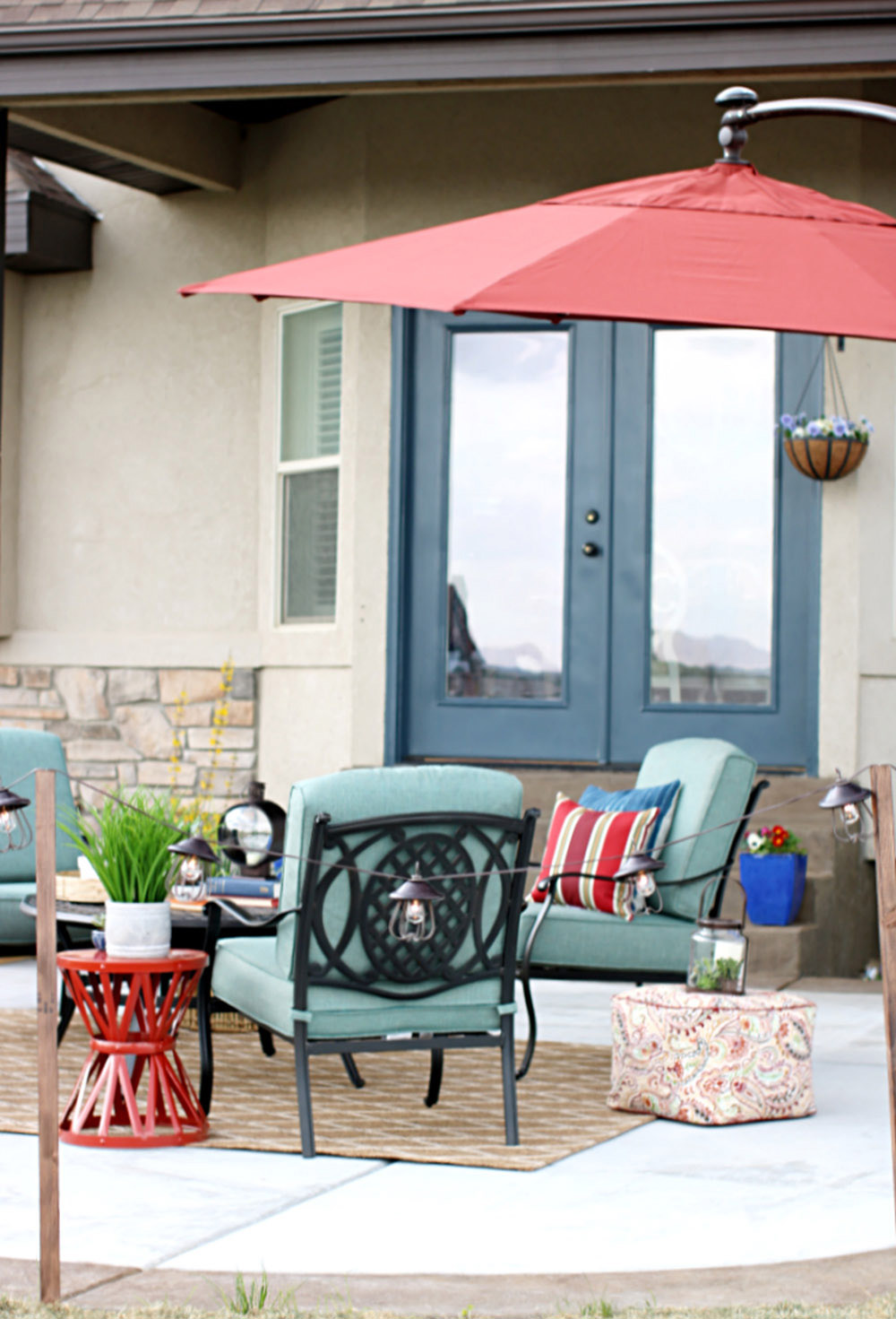 A red patio umbrella hangs over an outdoor seating area. A red patio umbrella hangs over an outdoor seating area.