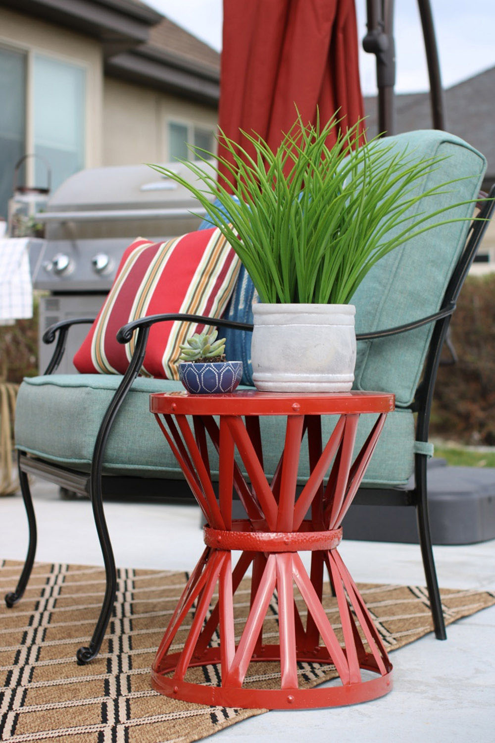 Two planters sitting on a red metal garden stool. Two planters sitting on a red metal garden stool.