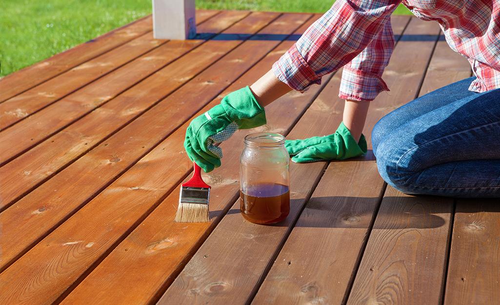 A person painting a deck.
