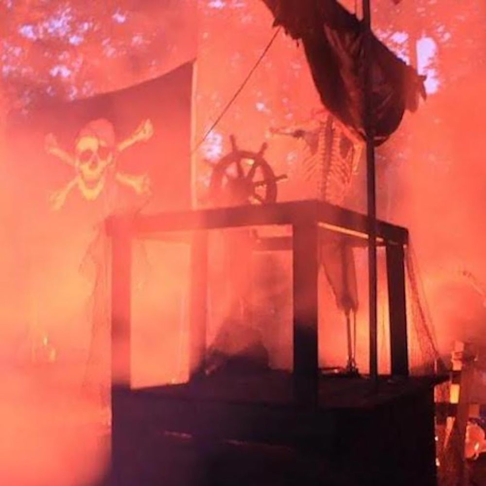 The flag on a pirate ship covered in orange fog.