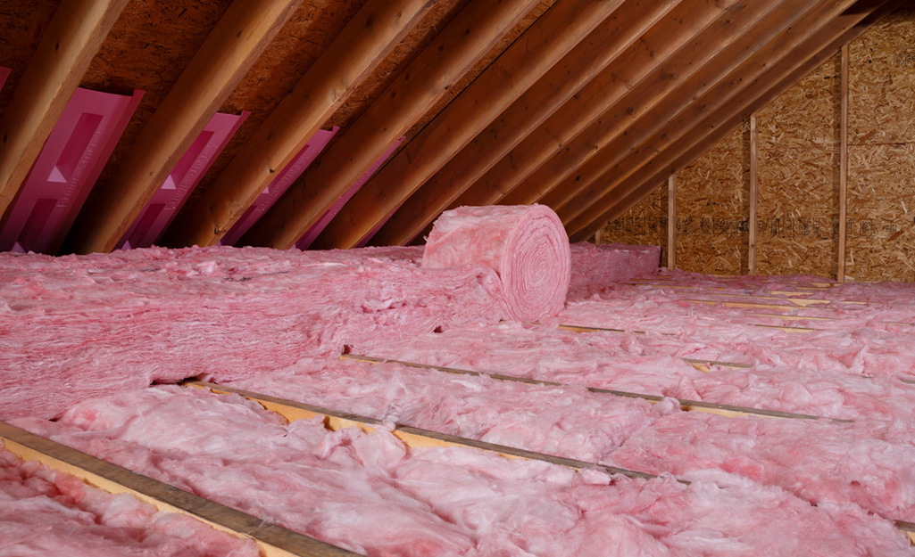 Insulation rolls in an attic crawl space.