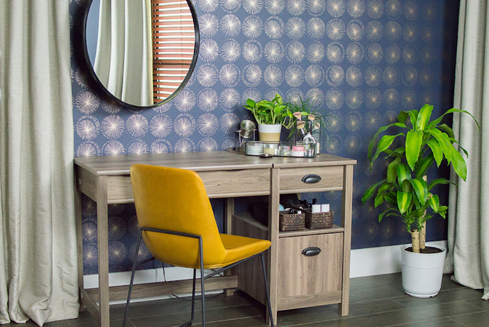 A room featuring blue and gold removable wallpaper is decorated with greenery and new furniture.