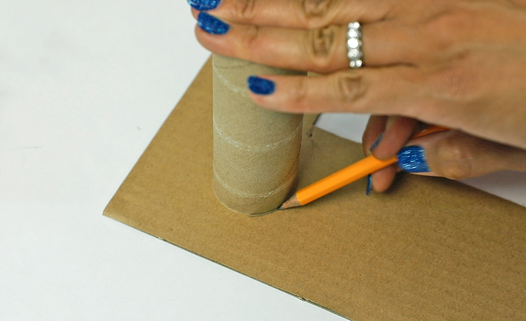 Woman tracing a toilet paper roll insert.