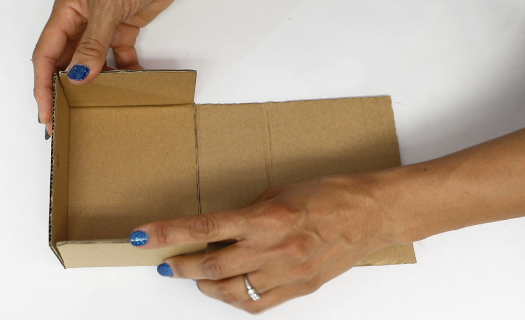 Woman folds the cardboard.