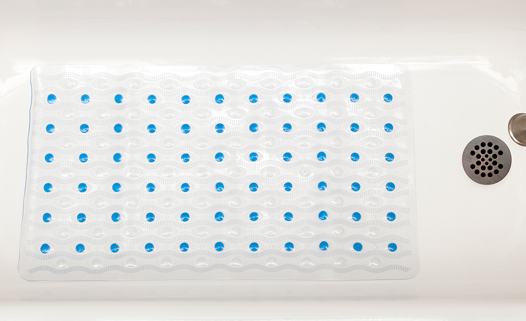 A nonslip mat is placed at the bottom of a bathtub. A nonslip mat is placed at the bottom of a bathtub.