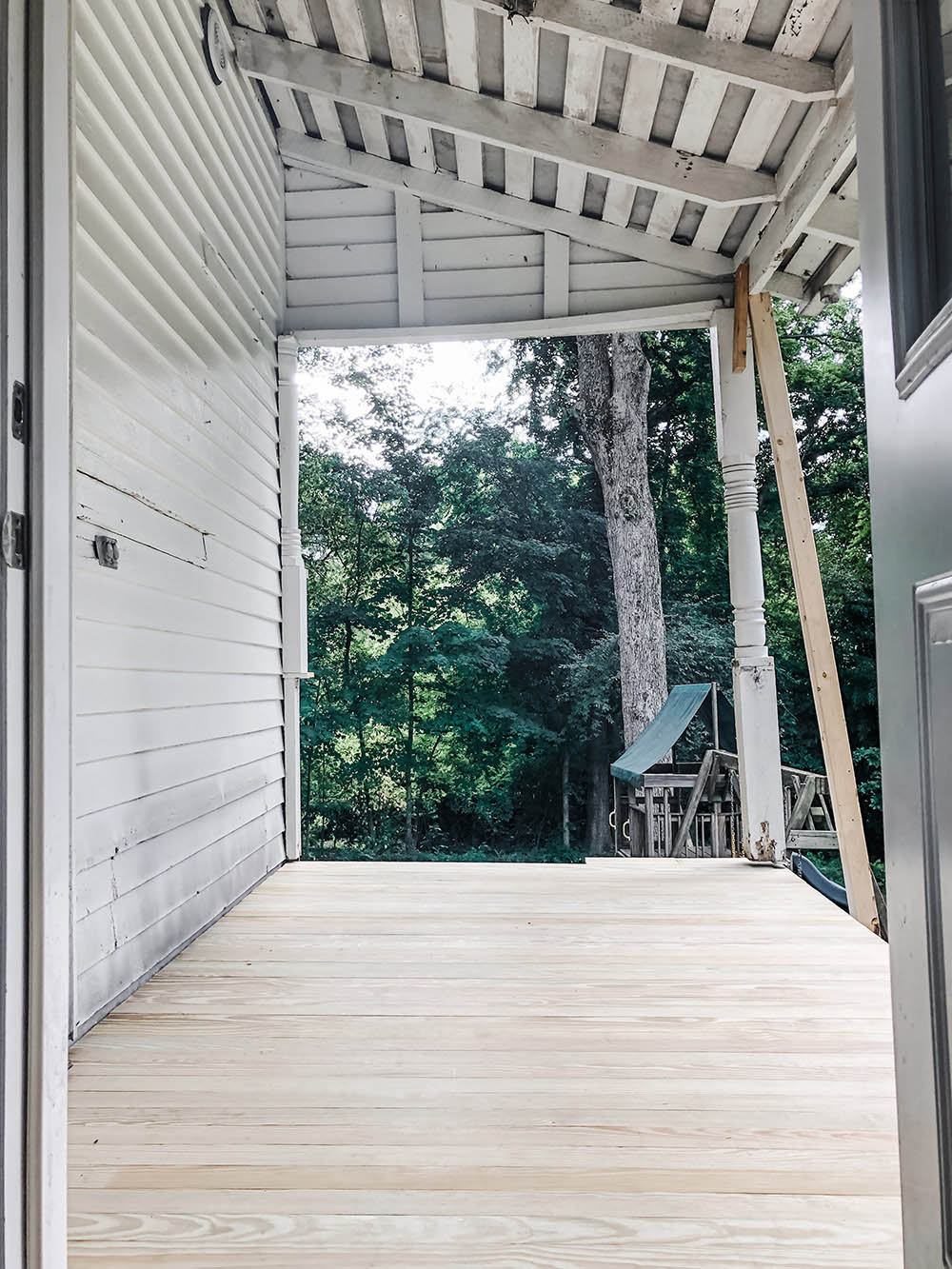 A back porch with new wooden flooring installed.