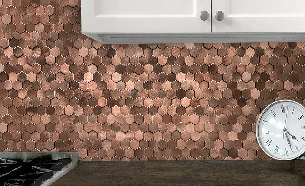 A penny backsplash in many shades of copper gives a shiny touch to a standard kitchen.