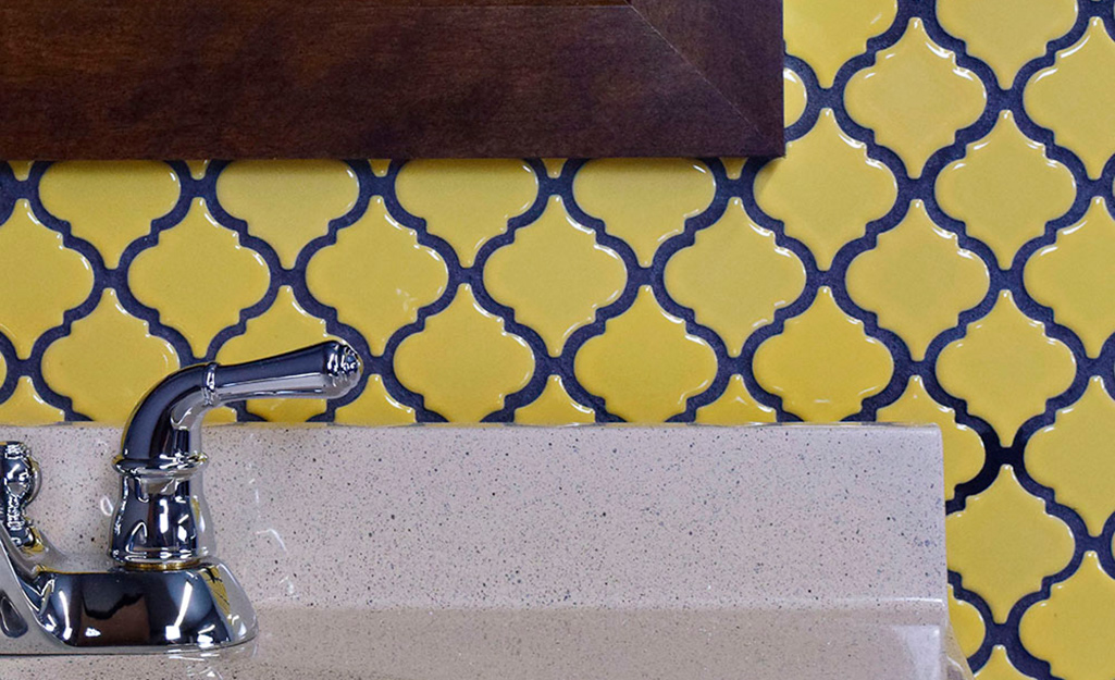 Buttercup yellow tile with blue grout in an ornate pattern makes a striking vintage backsplash.
