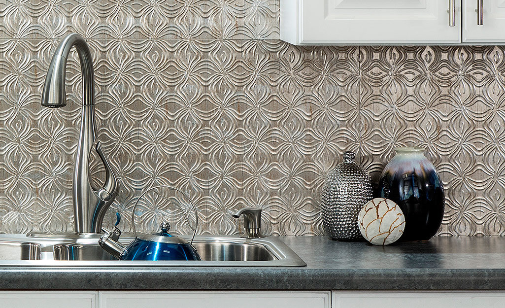 A pressed tin backsplash makes a striking backdrop in a modern kitchen.