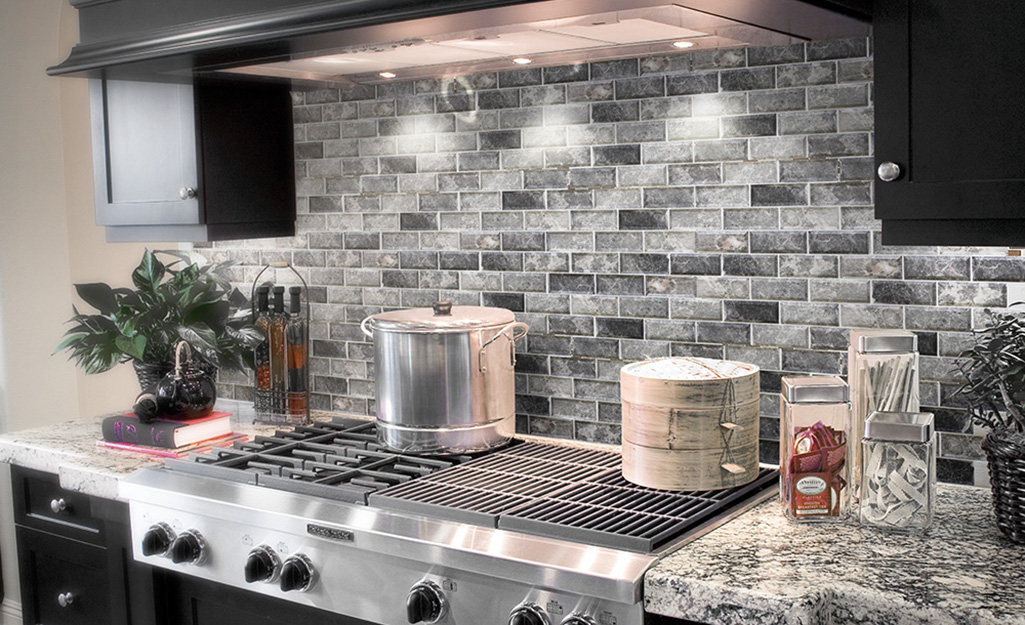 A marble tile backsplash echoes marble countertops in a classic kitchen.