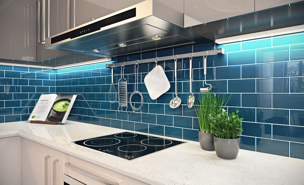 A bright backsplash of blue subway tile accents a modern kitchen.