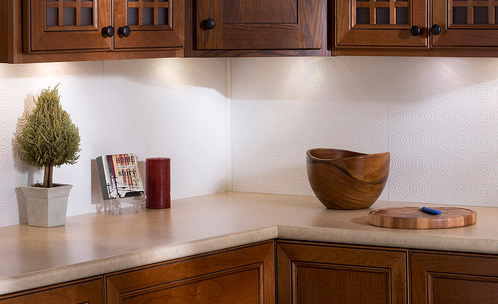 A white decorative wall paneling provides subtle interest as a backsplash for dark cabinets.