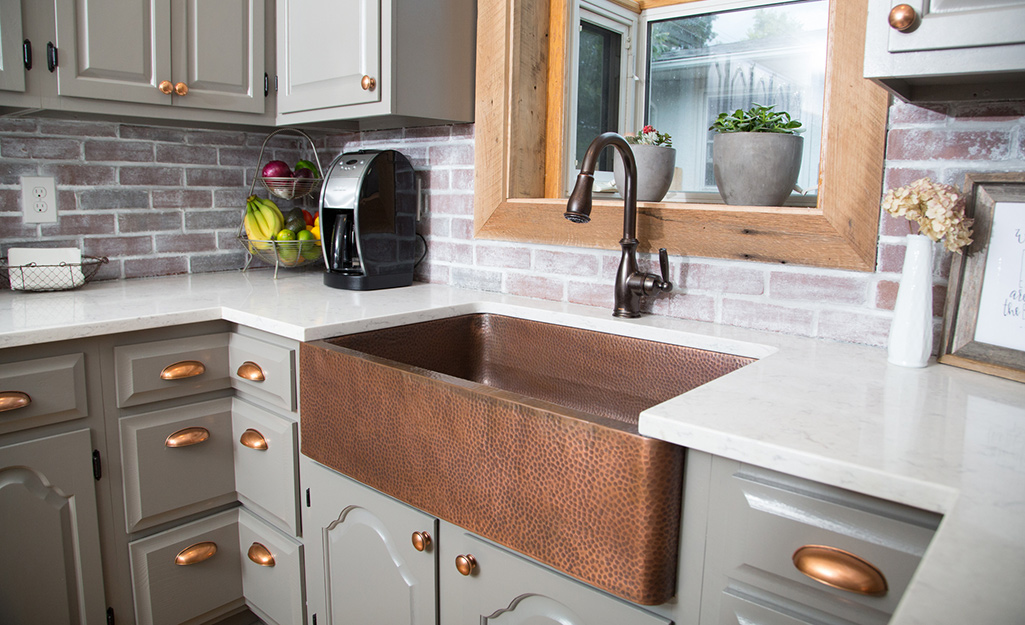 A weathered gray brick is a fitting backsplash for rustic kitchens.