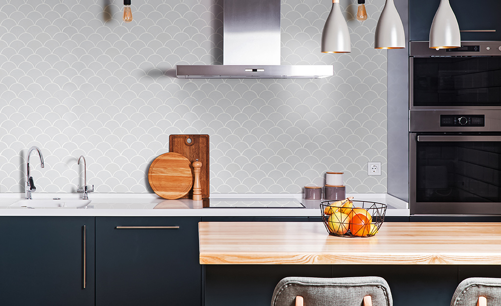 Pale gray fish scale tiles are a calming backsplash for a contemporary kitchen.
