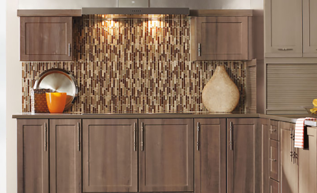 Monochromatic glass tile in brown matches wood and brings movement as a backsplash for a cottage kitchen.