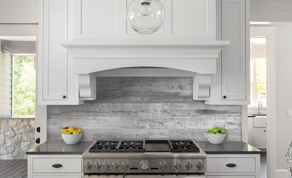 Worn driftwood tile gives a relaxed feel to a backsplash for a coastal kitchen.