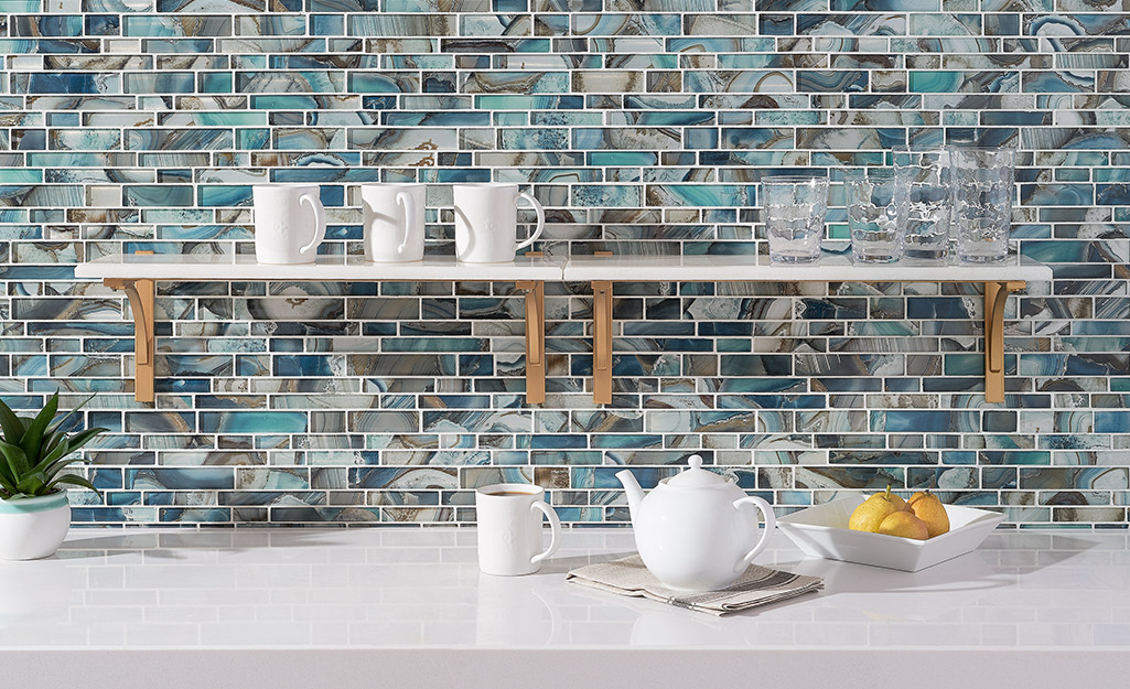 Small rectangular tiles in swirls of blue, gray, and brown make a stunning backsplash.