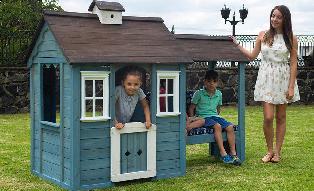 Children playing with a playhouse.