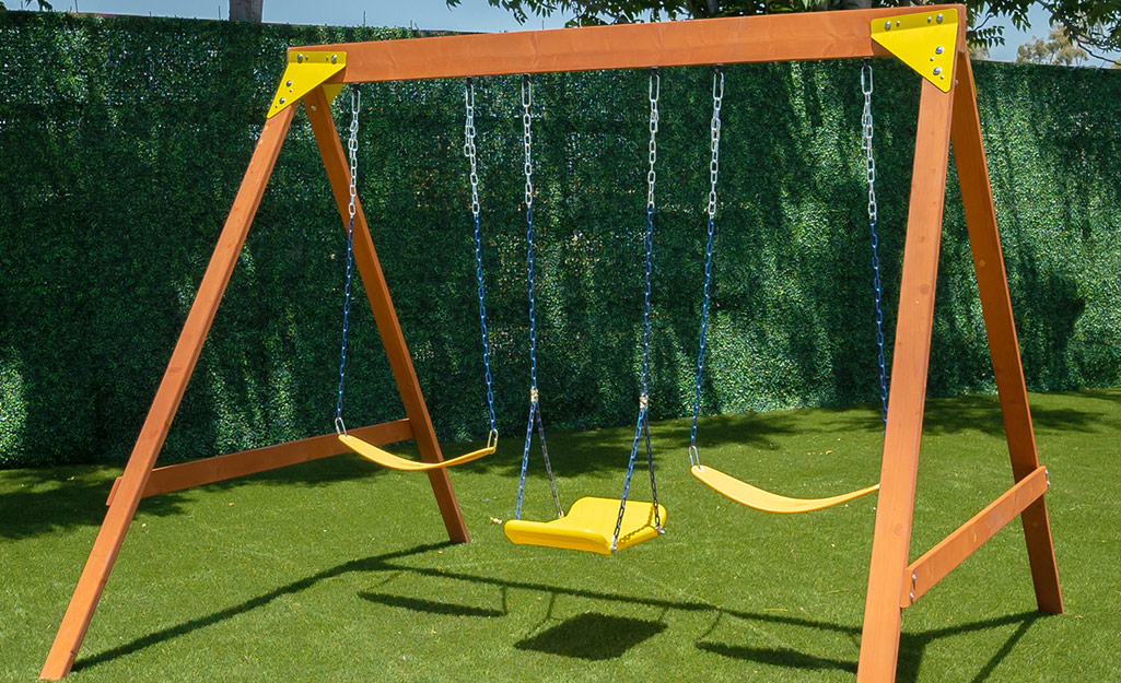A children's swing set set up in a backyard.