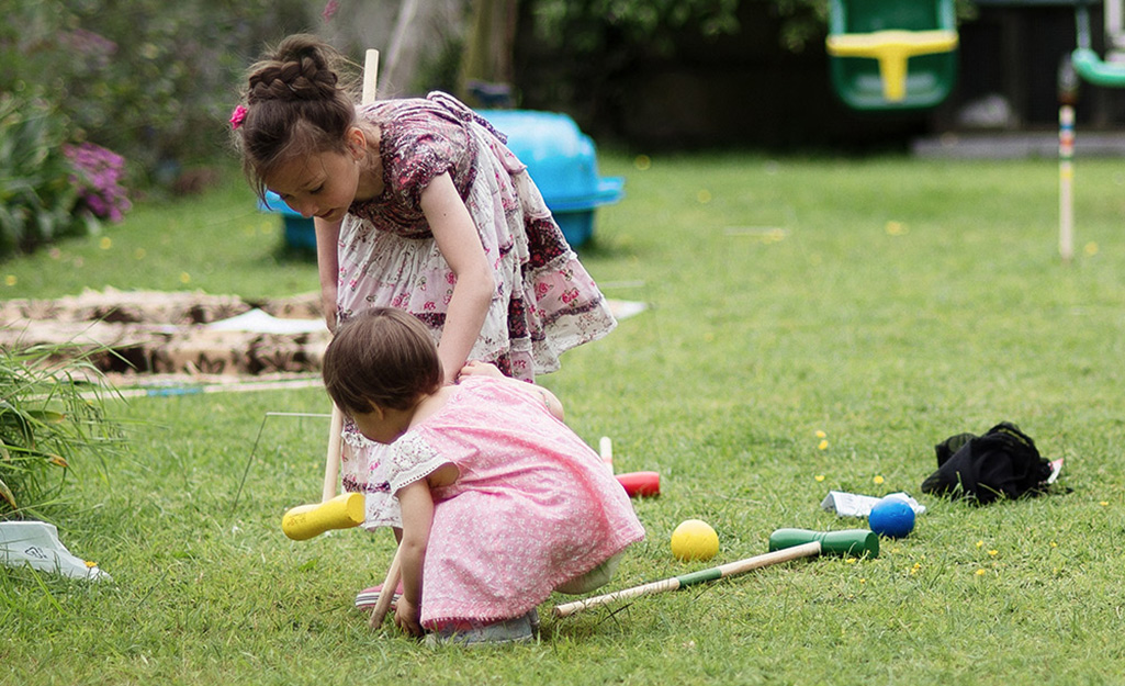 Children playing outdoors with a croquet set.