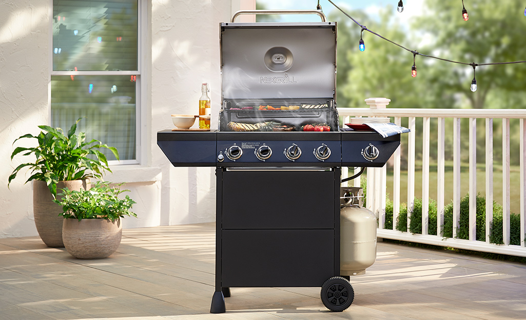 A backyard patio featuring a small grill