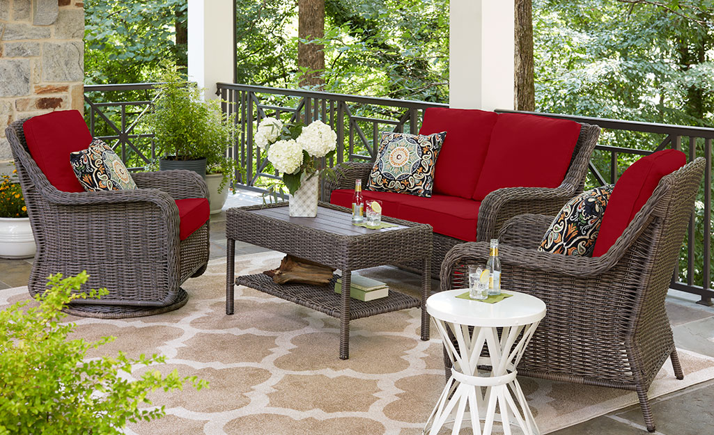 A balcony patio featuring furniture, accent pillows and an outdoor rug.