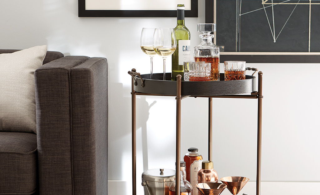A bar cart with bar accessories including an ice bucket, shaker and decanter. A bar cart with bar accessories including an ice bucket, shaker and decanter.