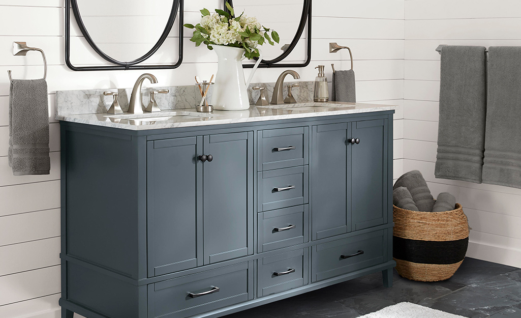 Farmhouse style vanity installed in front of a shiplap wall. Farmhouse style vanity installed in front of a shiplap wall.
