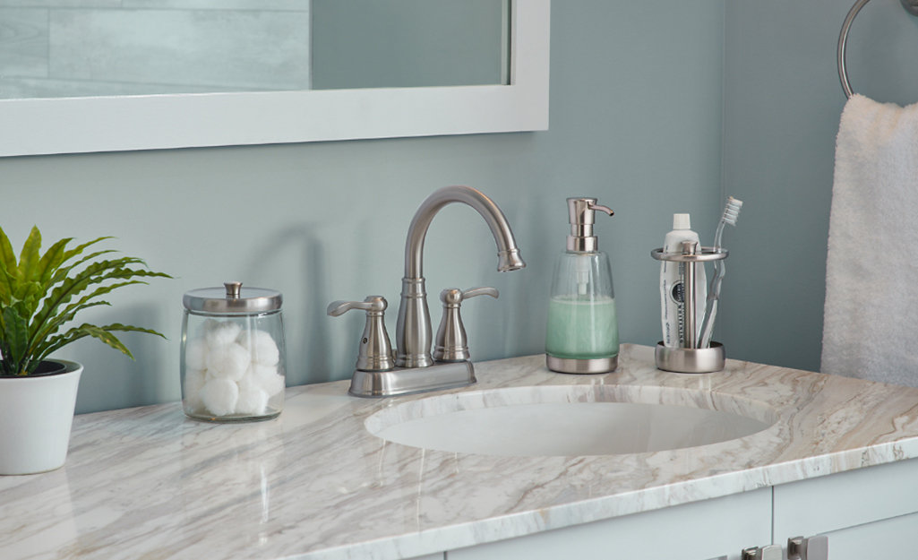 The top of a bathroom vanity with organized toiletries.