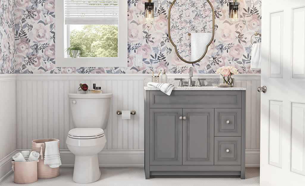 Flowered wallpaper and bead board installed behind a gray single vanity. Flowered wallpaper and bead board installed behind a gray single vanity.