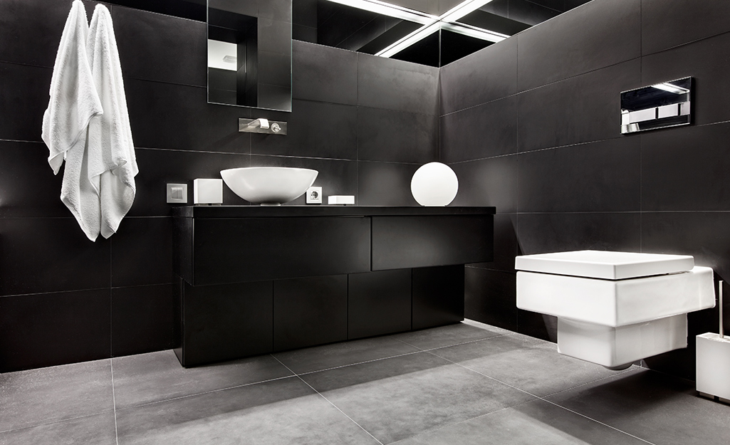 Bathroom painted black with white sinks and fixtures. Bathroom painted black with white sinks and fixtures.