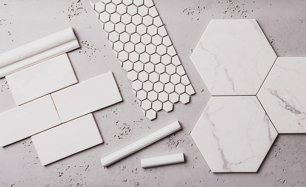 Different types of white ceramic tile laying on a counter.
