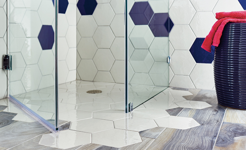 A shower with blue and white honeycomb tiles.