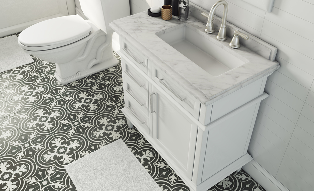 Black-and white patterned bathroom tiles with a white vanity.