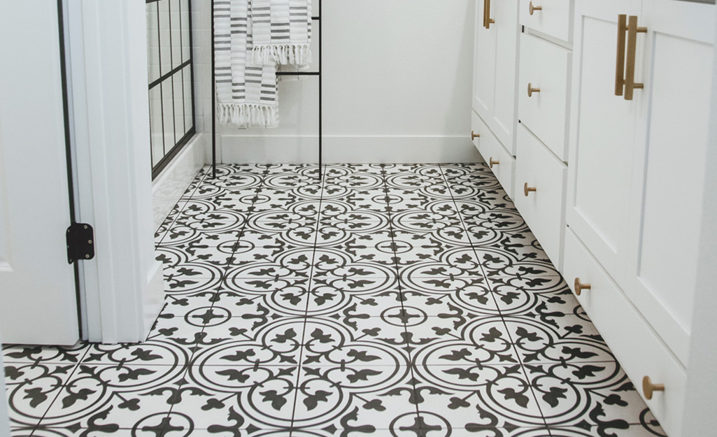 Black and white floor tile in a floral pattern.