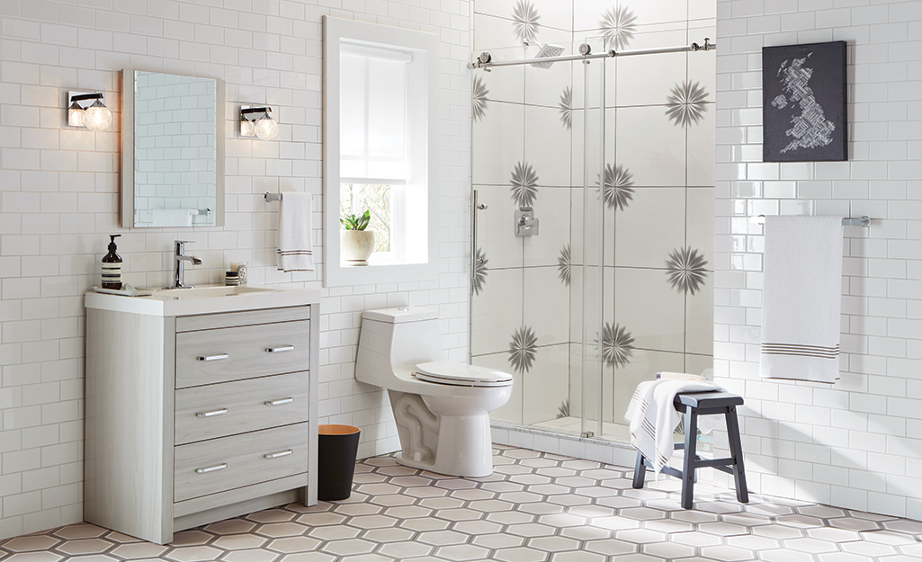 A shower with graphic tiles in contrast with the white floor tile design.