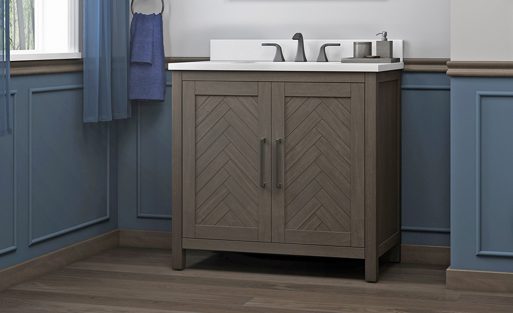 A farmhouse bathroom vanity with herringbone cabinet doors.