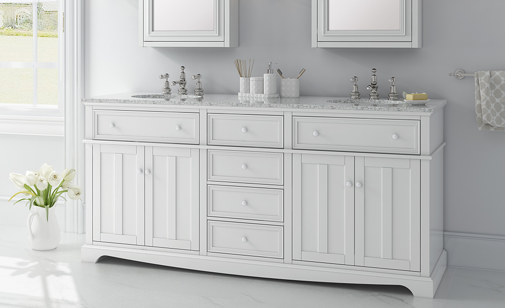 A white classic bathroom vanity with double sinks.