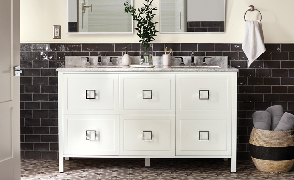 A white modern bathroom vanity with square drawers and square metal pulls.