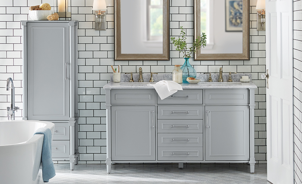 A gray double sink vanity in a large master bathroom.