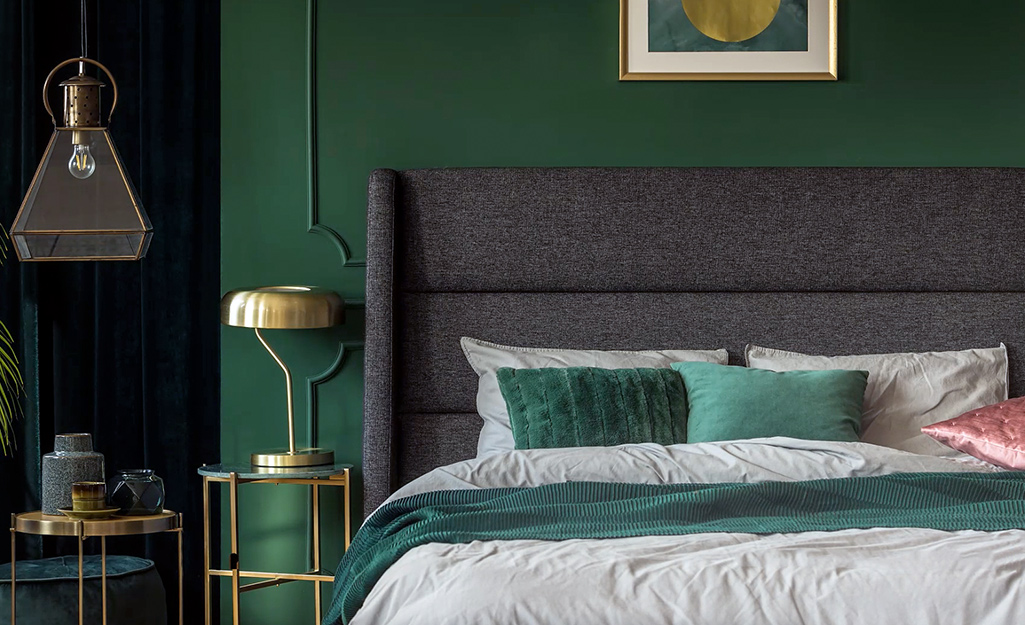 A bedroom featuring a bold green accent wall behind the bed.