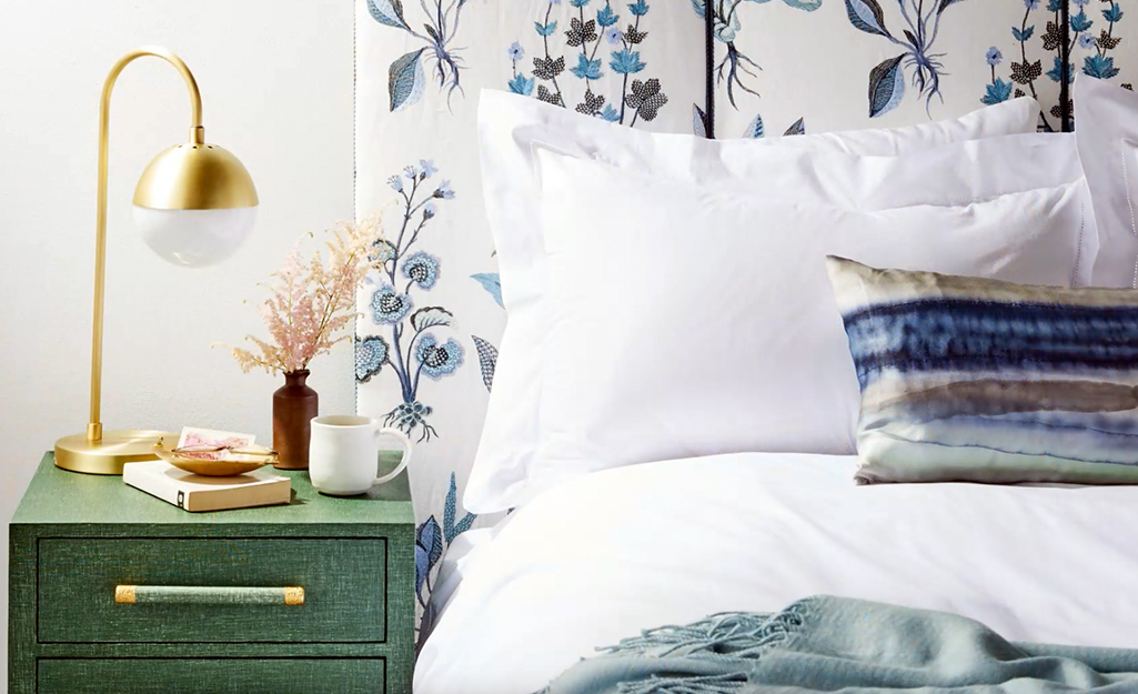 A plush three paneled headboard covered in a soothing blue and green floral.