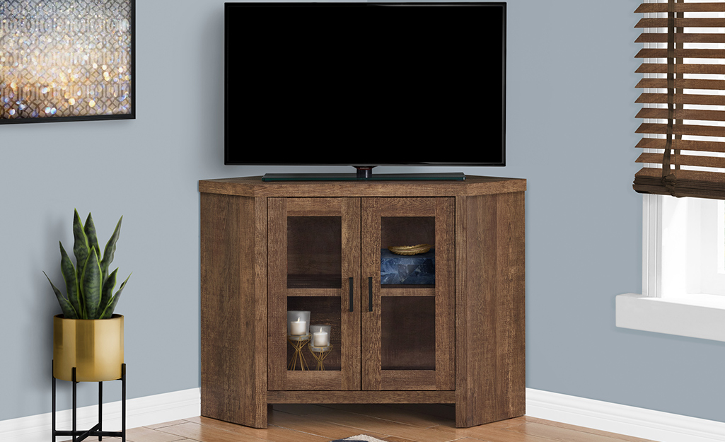 A picture of a TV stand designed to fit into a room corner.