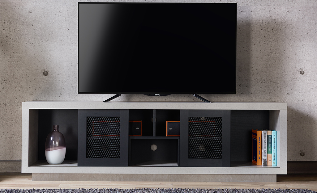 A picture of a flat TV on a stand crafted from particle board.