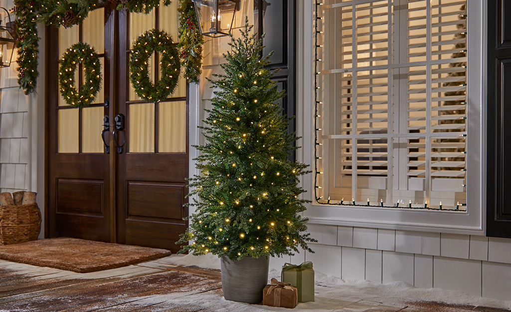 An artificial potted Christmas Tree in an entryway.