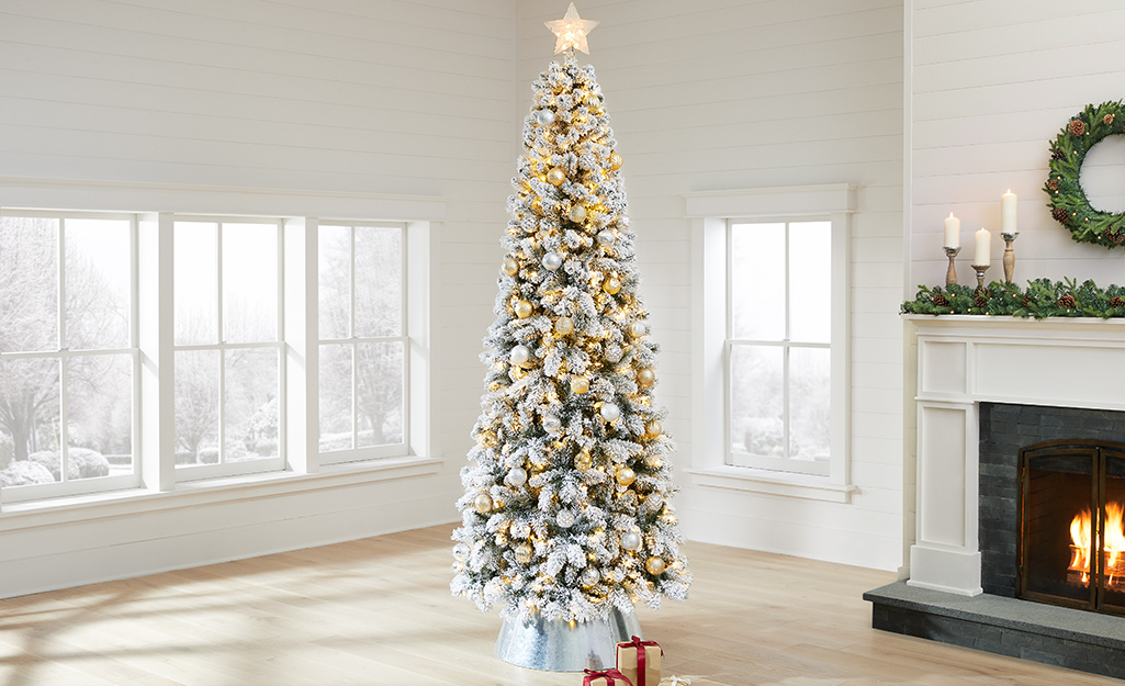 A flocked Christmas tree with white, silver and gold decorations.